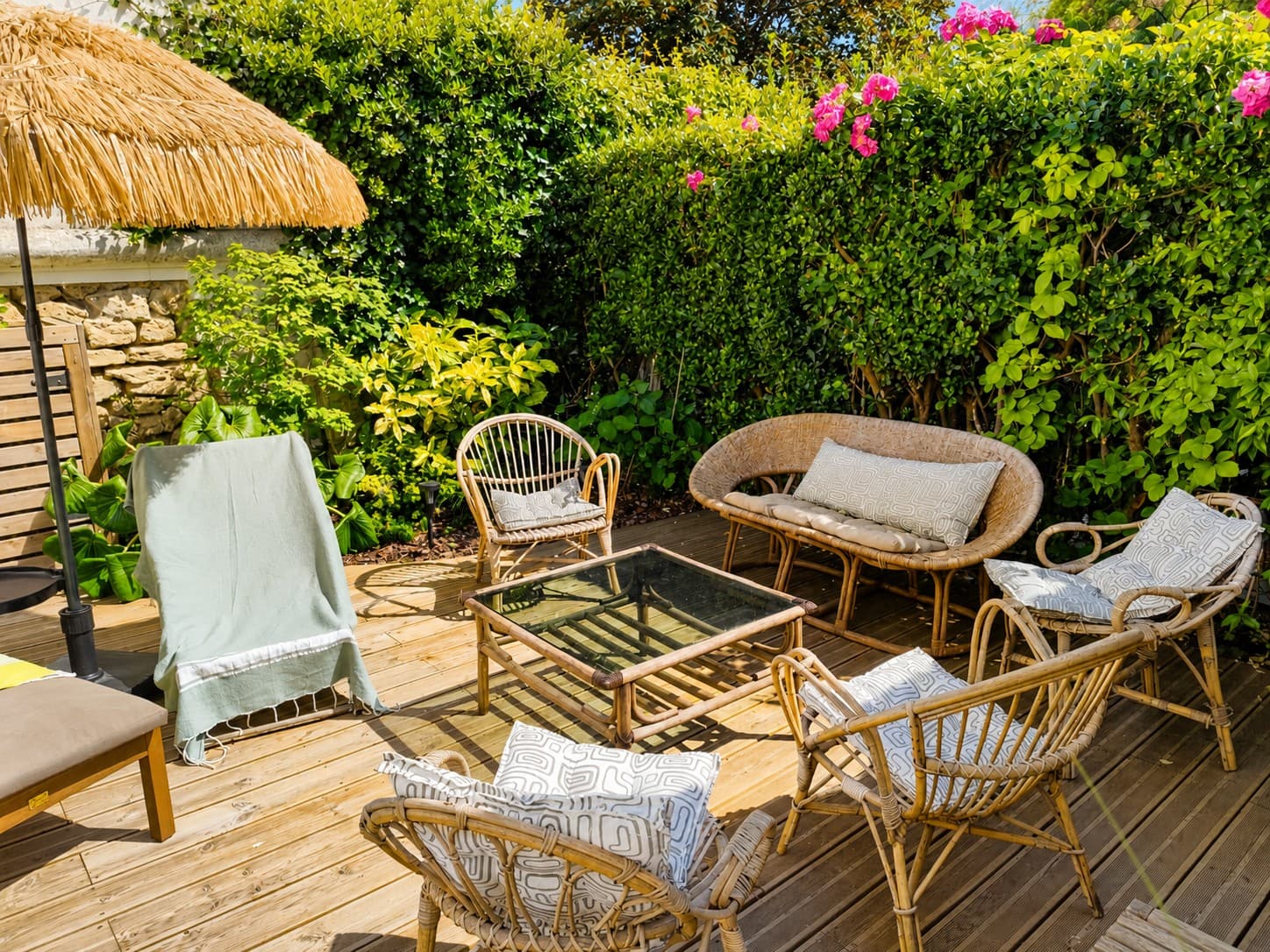 Terrasse avec fauteuils, parasol et jardin fleuri