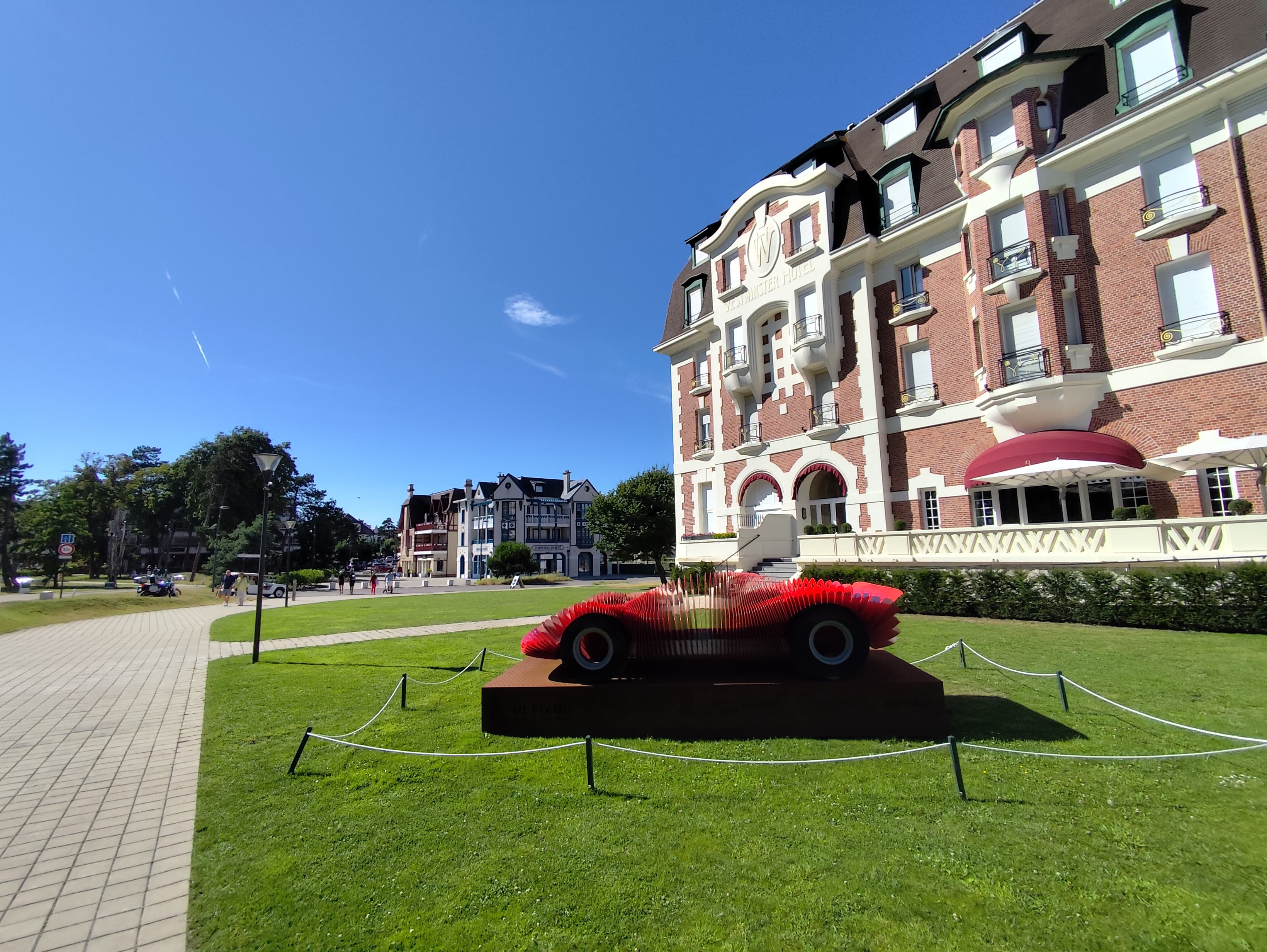 Façade de brique rouge et de pierre claire d’un grand hôtel historique du Touquet, sous un ciel bleu